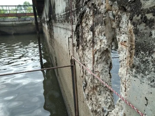 Разрушенная бетонная стенка отстойника на границе вода–воздух